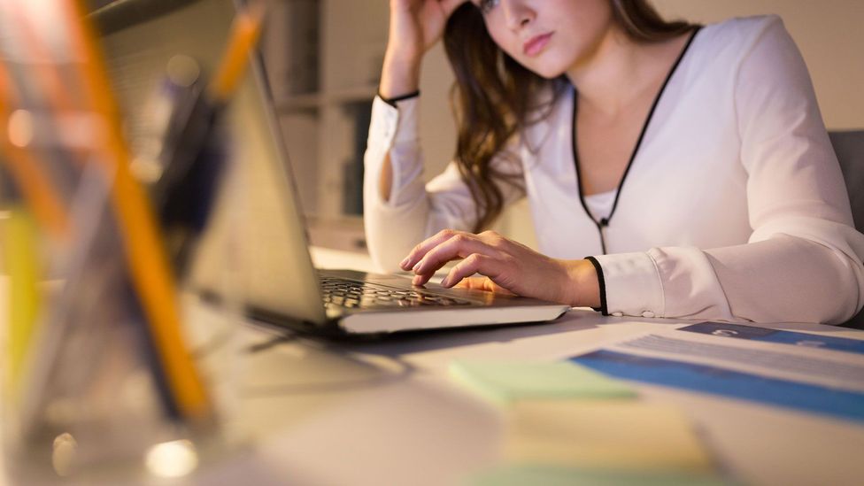 an unhappy woman in front of her laptop
